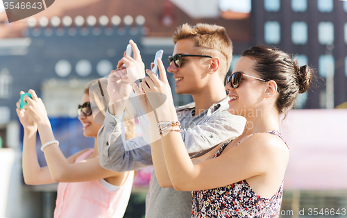 Image of smiling friends with smartphone taking picture