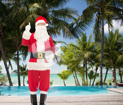 Image of man in costume of santa claus pointing finger up