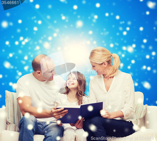 Image of happy family with book at home