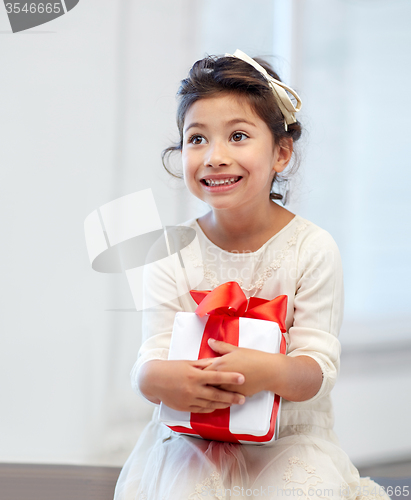 Image of happy little girl with gift box at home