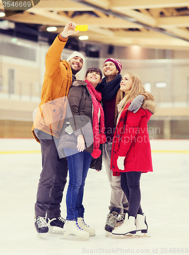 Image of happy friends taking selfie on skating rink