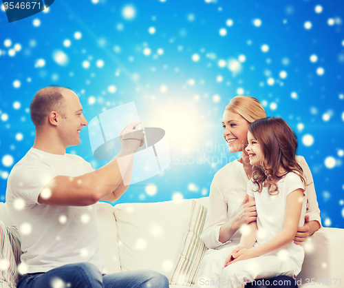Image of happy family with camera at home