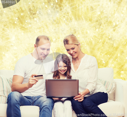 Image of happy family with laptop computer and credit card