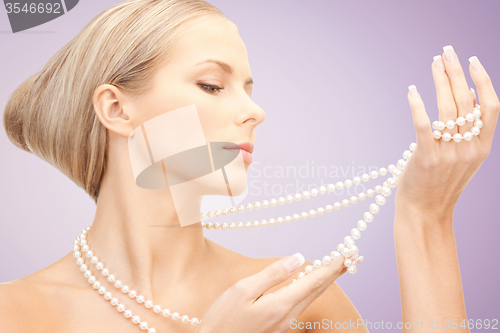 Image of beautiful woman with pearl necklace over violet