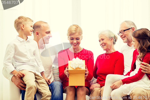 Image of smiling family with gift at home