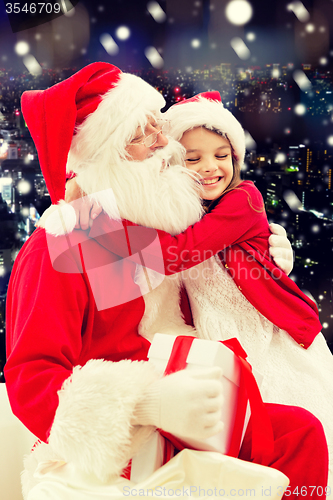 Image of smiling little girl with santa claus and gifts