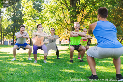 Image of group of friends or sportsmen exercising outdoors