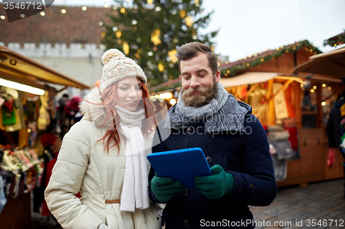 Image of happy couple walking with tablet pc in old town