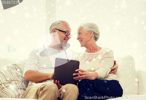 Image of happy senior couple with tablet pc at home