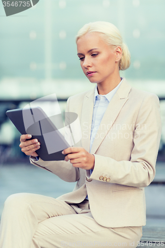 Image of businesswoman working with tablet pc outdoors