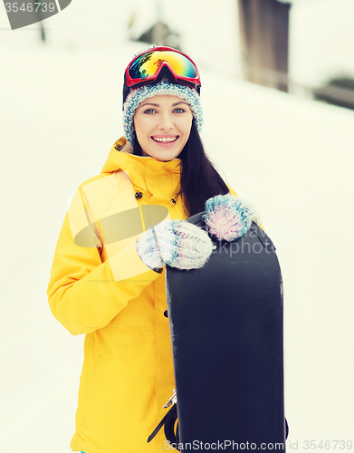 Image of happy young woman with snowboard outdoors