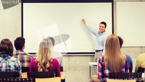 Image of group of students and smiling teacher in classroom