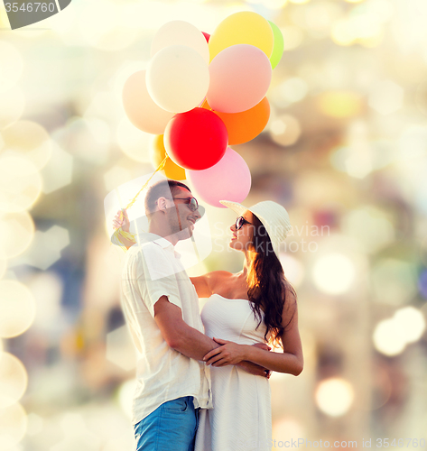 Image of smiling couple with air balloons outdoors