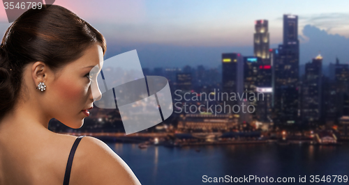 Image of woman with diamond earring over night city