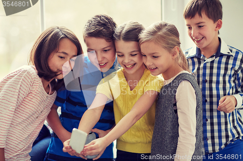 Image of group of school kids taking selfie with smartphone