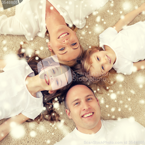 Image of parents and two girls lying on floor at home