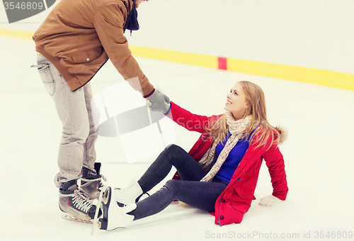 Image of man helping women to rise up on skating rink