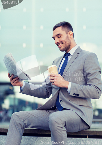 Image of young businessman with coffee and newspaper