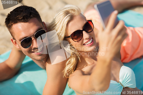 Image of happy couple in swimwear walking on summer beach