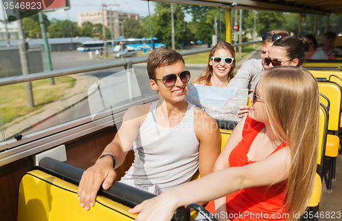 Image of group of smiling friends traveling by tour bus