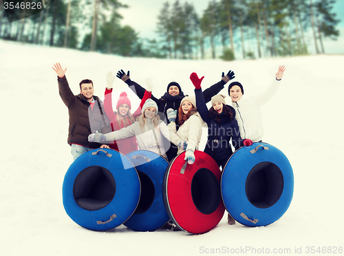 Image of group of smiling friends with snow tubes