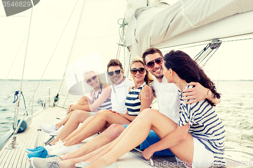 Image of smiling friends sitting on yacht deck