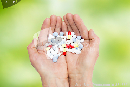 Image of close up of senior woman hands with pills