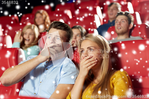 Image of friends or couple watching horror movie in theater