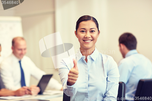 Image of group of smiling businesspeople meeting in office