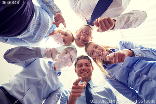 Image of smiling group of businesspeople standing in circle