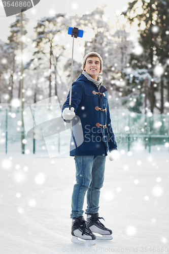 Image of happy young man with smartphone on ice rink