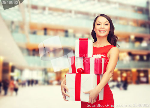 Image of smiling woman in red dress with gift box