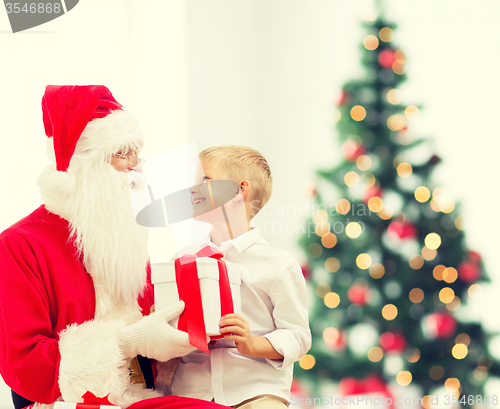 Image of smiling little boy with santa claus and gifts