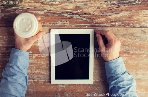 Image of close up of male hands with tablet pc and coffee