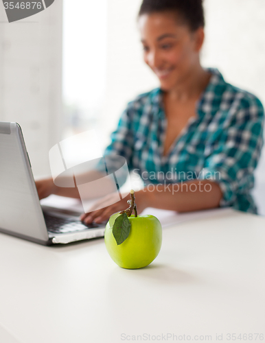 Image of close up of student girl with laptop and apple