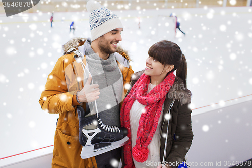 Image of happy couple with ice-skates on skating rink