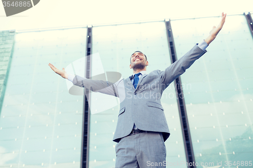 Image of young smiling businessman over office building