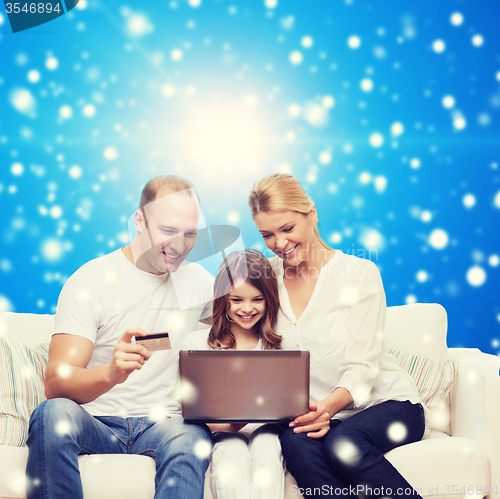 Image of happy family with laptop computer and credit card