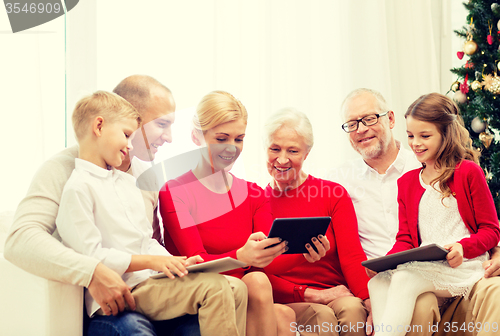 Image of smiling family with tablet pc computers at home