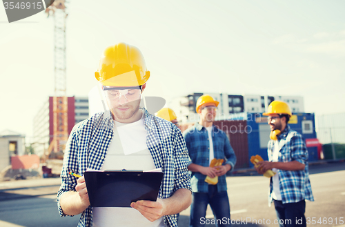 Image of group of builders in hardhats outdoors