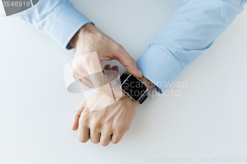 Image of close up of male hands setting smart watch