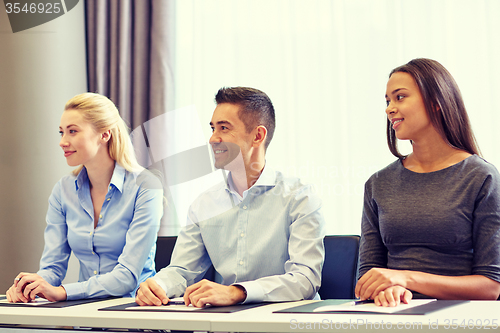 Image of group of smiling businesspeople meeting in office