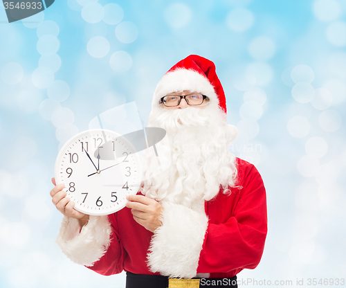 Image of man in costume of santa claus with clock