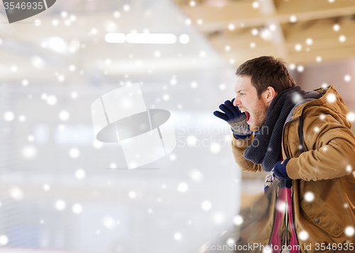 Image of young man supporting hockey game on skating rink