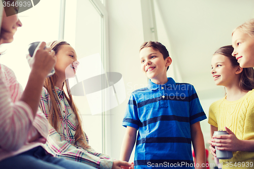 Image of group of school kids with soda cans in corridor