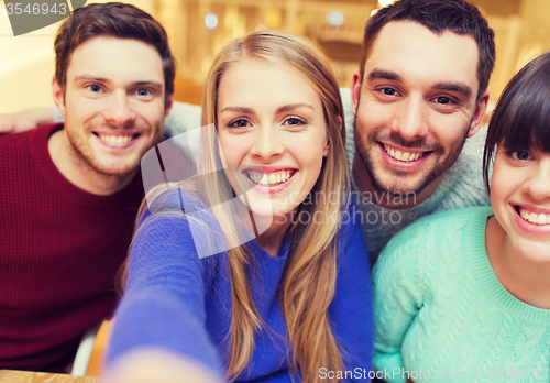 Image of group of smiling friends taking selfie