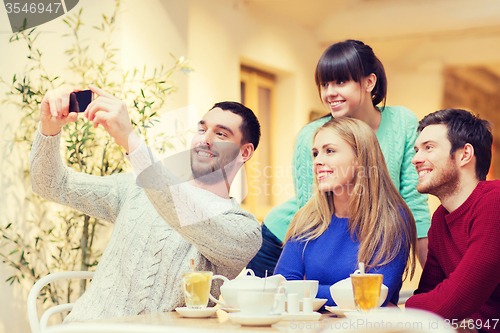 Image of group of friends taking selfie with smartphone