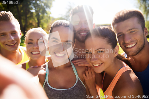 Image of happy friends taking selfie with smartphone
