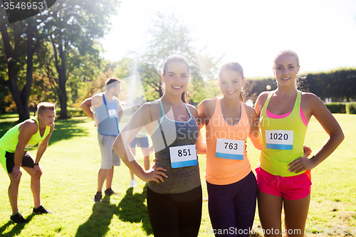 Image of happy young sporty women with racing badge numbers