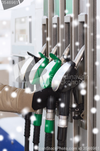 Image of close up of man with fuel hoses at gas station